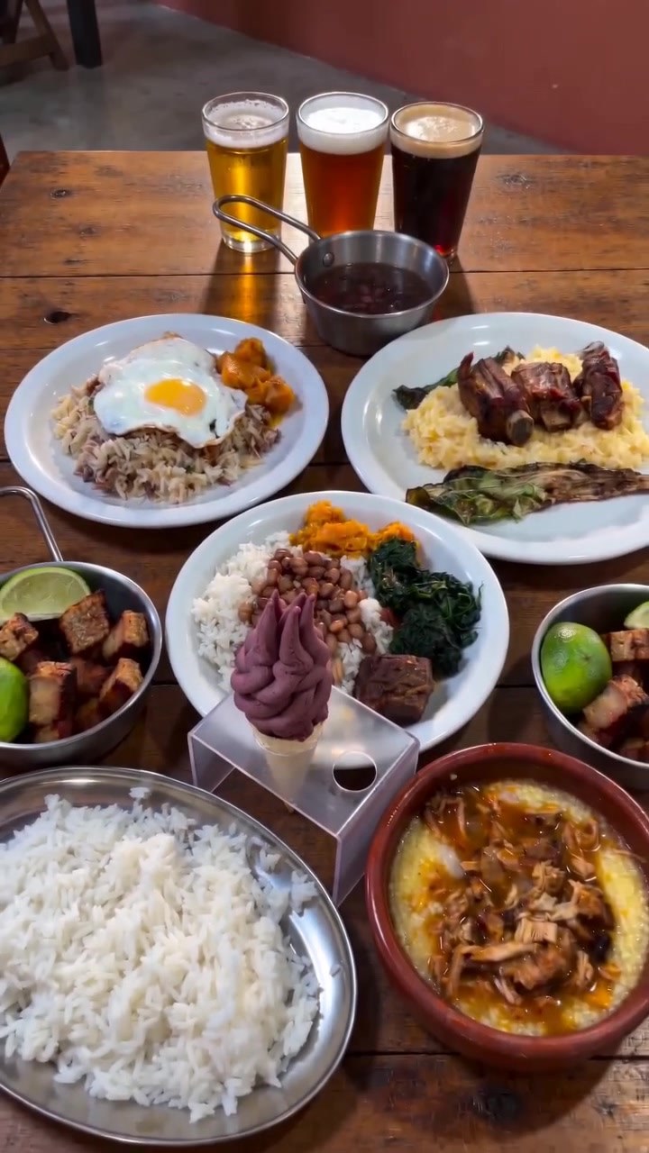 Mesa completa da Comedoria com pratos caipiras, acompanhamentos, sorvete e três chopps